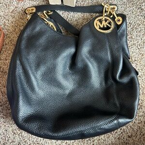 3 large pocket Michael Kors black and gold shoulder bag.